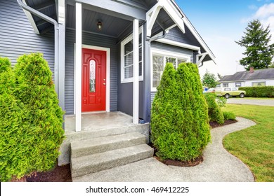 Classic American House Exterior With Siding Trim, Red Entry Door And Concrete Floor Porch. Northwest, USA