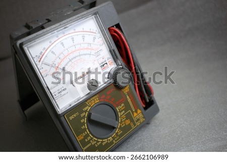 Classic analog avometer (multimeter) with needle gauge displayed on a clean background. A vintage yet reliable tool used to measure voltage, current, and resistance. Essential for electricians, techni