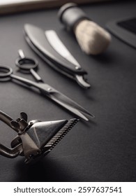 Classic barber tools including scissors, a straight razor, and a shaving brush are neatly organized on a dark surface, emphasizing traditional grooming techniques used by barbers.