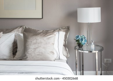 Classic Bedroom Style With Set Of Pillows On Bed And White Lamp On Table Side