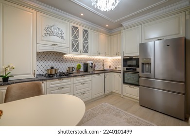 Classic beige kitchen with ample counter space and a variety of appliances - Shutterstock ID 2240101499