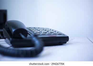 Classic Black Land Line Telephone On Wooden Desk. Selective Focus With Shallow Depth Of Field.