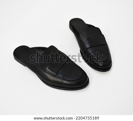 Classic black leather slide loafers on white background, basic spring slides, chunky mules for women  