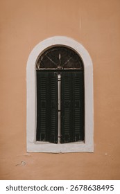 Classic Black Shutter on a Rustic Wall, Evoking Mediterranean Charm. Vintage Green Window with Shutters on Wall