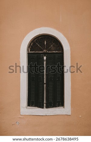 Classic Black Shutter on a Rustic Wall, Evoking Mediterranean Charm. Vintage Green Window with Shutters on Wall