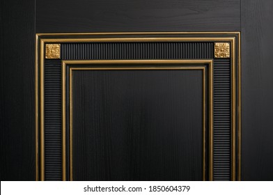 Classic black wooden entrance door with carved panels and Golden patina