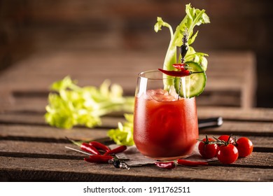 Classic bloody mary or virgin mary vodka cocktail in a cup with as a hangover drink in a rustic envrionment.