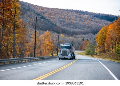 Classic Blue Day Cab Industrial Grade Professional Big Rig Semi Truck Transporting Fuel In Tank Semi Trailer Climbing Uphill On The Winding Road In Autumn Mountain In Vermont New England