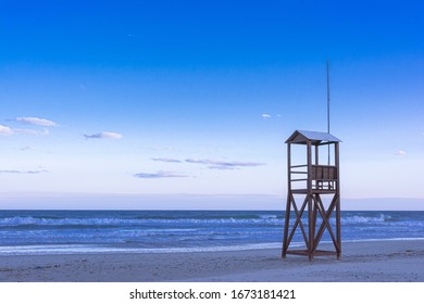 Classic Blue nediterranean beach sunrise with lonely lifeguard wooden tower, Deep blue style