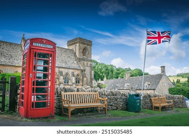 A classic British village with church, red telephone booth and Union Jack - Powered by Shutterstock