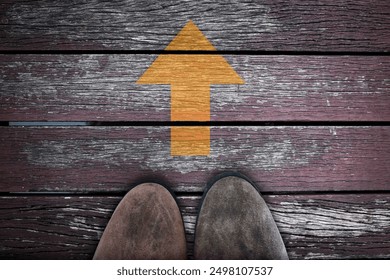 Classic brown sneaker tip standing on wooden board, vintage pink wooden bridge. With yellow arrow pointing straight up. Conceptual image conveying progress, moving forward, life, positive attitude. - Powered by Shutterstock