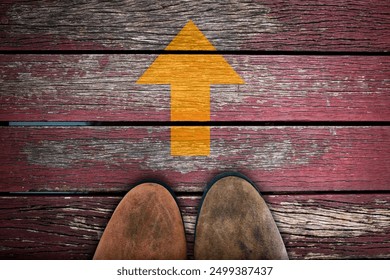 Classic brown sneaker tip standing on wooden board, vintage pink wooden bridge. With yellow arrow pointing straight up. Conceptual image conveying progress, moving forward, life, positive attitude. - Powered by Shutterstock