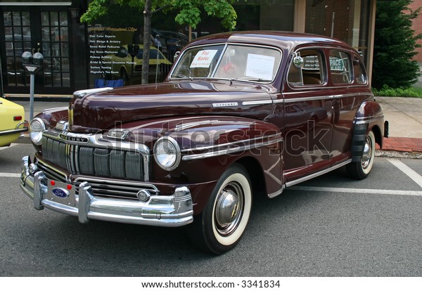 A\
classic car displayed at a street antique car\
show