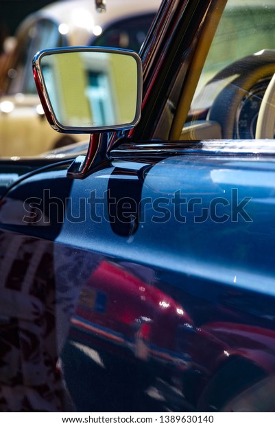 Classic car mirror. Shiny vintage car. Old\
blue car body. Chrome classy old car mirror.\
