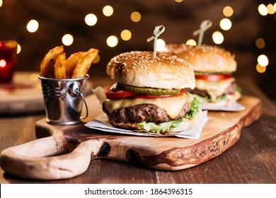 Classic cheeseburger with baked potatoes served on wooden board in holiday spirit
