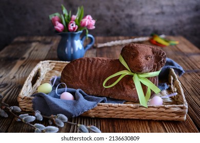 Classic chocolate Easter lamb pound cake sprinkled with cocoa powder on wooden background