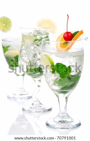 Classic Citrus Mojito cocktails with light rum, vodka, gin, lime, spring of mint, simple soda, orange, maraschino cherry and syrup in cocktail glasses isolated on a white background