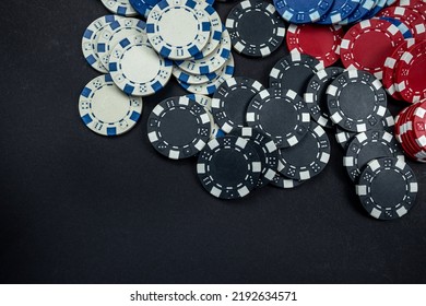 Classic Colored Round Poker Chips Scattered On A Black Table. Isolated Poker Concept. Gambling