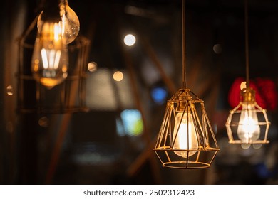 Classic designed ceiling lighting bulb with iron cage, it glowing in orange warm light shade. Object for interior decoration, close-up with selective focus.