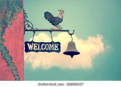 Classic Door Bell With Silhouette  Of  Chicken, Vintage Welcome Label  On Blue Sky With Cloud