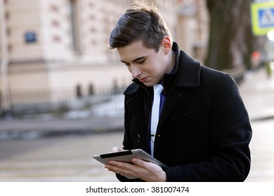 Classic dressed young man with a tablet pc. - Shutterstock ID 381007474