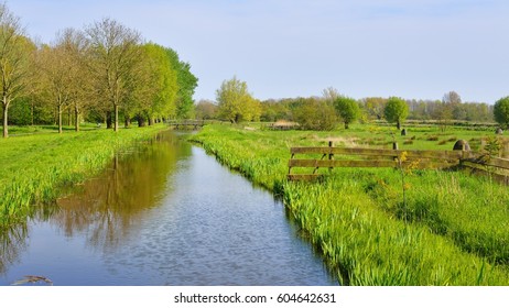 Classic Dutch landscape. Polder ditch canal on a green grass field. - Shutterstock ID 604642631