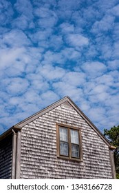 A Classic East Coast Home On Nantucket Island, Massachusetts, At An Angle With A Unique Cloud Formation Above.