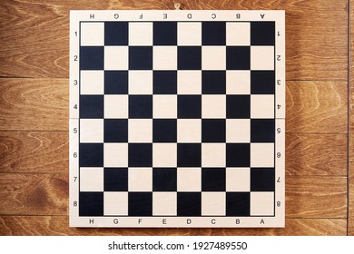 Classic empty chessboard on the brown wooden table. Layout template for chess strategy and tasks