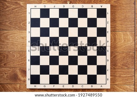 Classic empty chessboard on the brown wooden table. Layout template for chess strategy and tasks