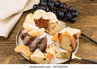 Classic English Christmas Cake With Tangerines On A Ceramic Plate. Side View. Wooden Background