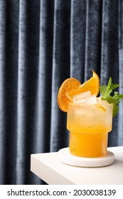 Classic Freshness Cocktail, Mojito, Lemonade Or Mai Tai With Lime, Orange On Podium On Blue Background Of Curtain. Summer Holiday Mocktail.