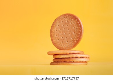 Classic Golden Maria Cookie. Pile Of 5 Cookies Viewed Up Close With A Yellow Background.