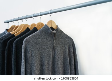 Classic Gray And Black Men's Luxury Cashmere Wool Sweaters On Hangers With Copy Space. Fashion For The Cold Season