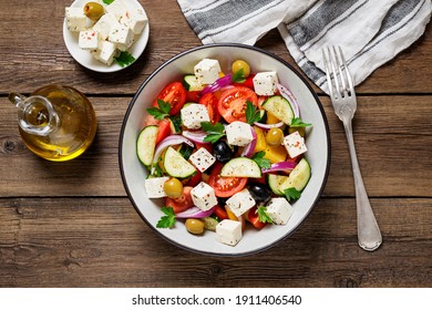 Classic Greek salad with fresh vegetables, feta cheese and  olives. Healthy food. Wooden background. Top view - Powered by Shutterstock