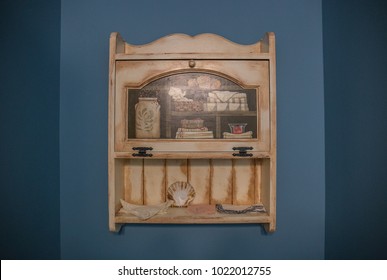 A Classic Handmade, Hand Painted, Wooden Bathroom Cabinet Decorated With A Tole Painting Of Jars And Other Objects.
