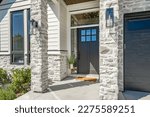 classic home exterior with cement tile patio deck stone entry wide front door patio with chairs and a fire pit area with trees and bbq seating dining on a bright sunny colorful day blue sky 