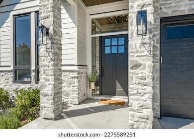 classic home exterior with cement tile patio deck stone entry wide front door patio with chairs and a fire pit area with trees and bbq seating dining on a bright sunny colorful day blue sky  - Shutterstock ID 2275589251