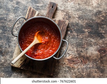 Classic Homemade Tomato Sauce In The Pan On A Wooden Chopping Board On Brown Background, Top View. Pasta, Pizza Tomato Sauce. Vegetarian Food 