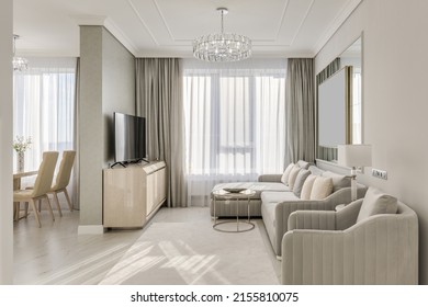 Classic interior design large bright room in neutral colors with furniture and chandelier