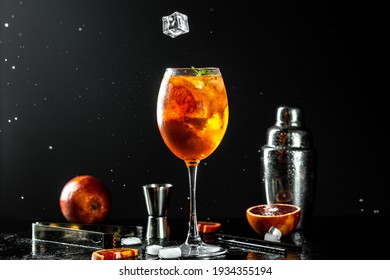 Classic italian aperol spritz cocktail in glass. liquid splash, freeze motion in jar glass on dark background.
