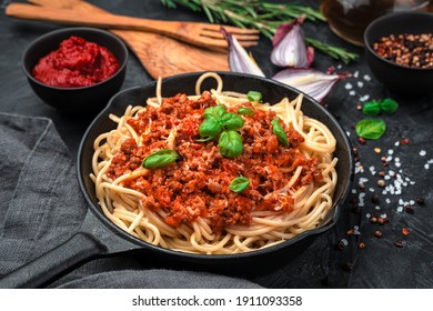 Classic Italian dish pasta bolognese on a black background. Top view, horizontal. Cooking concept.