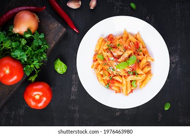 Classic Italian Pasta Penne Alla Arrabiata With Basil And Freshly Grated Parmesan Cheese On Dark Table. Penne Pasta With Chili Sauce Arrabbiata. Top View, Above, Copy Space