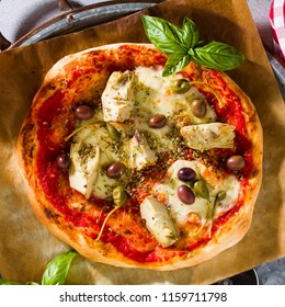 Classic Italian Pizza Margherita with artichokes, olives and capers on a table with beer and a knife. Banner for restaurants, advertising. - Powered by Shutterstock