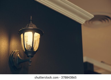 Classic Lamp On Black Wall, Vintage Filtered Image.