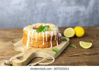 Classic lemon loaf cake on a wooden board, garnished with frosting and lemon shavings. Fast and tasty dessert - Shutterstock ID 2075523211