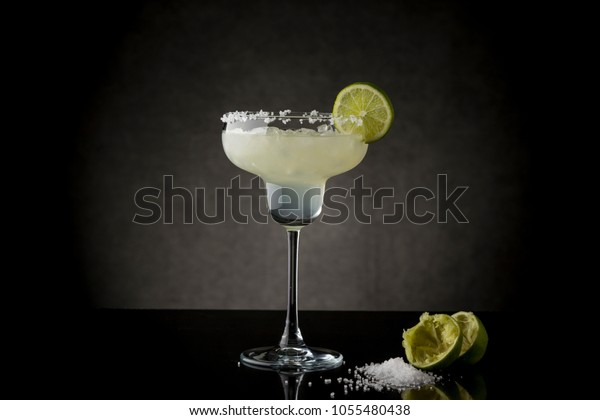 Classic lime margarita cocktail with\
tequila, triple sec, lime juice, crushed ice and some salt on the\
rim of a glass, decorated with a slice of\
lime