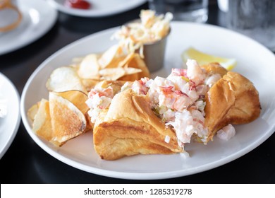 Classic Lobster Roll Sandwich Tossed In Mayonnaise, Served With Gourmet Potato Chips, At A New England Seafood Restaurant