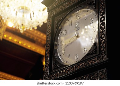Classic long-case clock with luxury ceiling light background, use for old and ornate decorative concept.