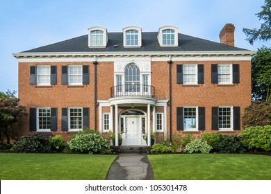 Classic luxurious red brick house with green lawn
