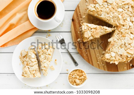 Classic Napoleon cake with coffee cup top view. Traditional millefeuille dessert with puff pastry and custard, russian cuisine treat, copy space